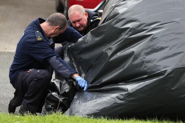 Members of the Gardai inspect the vehicle in which the man was shot  (Brian Lawless/PA)
