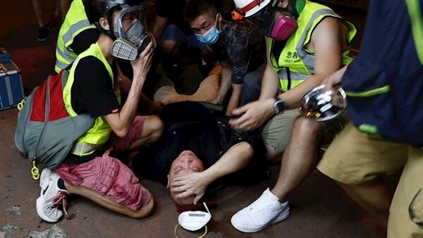 A protester is overcome by tear gas near the Shum Shui Po police station in Hong Kong today.