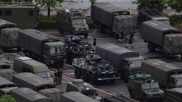 Armored vehicles and troop trucks are parked in a lot by Shenzhen Bay Stadium in Shenzhen on Saturday. Pic: AP