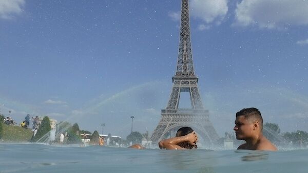 People cool off in the fountain of the Trocadero, as the Eiffel Tower is visible in background, in Paris, Tuesday, June 25, 2019.
