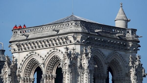 Firefighters survey damage atop a tower of Notre Dame cathedral. Picture: AP /Francois Mori
