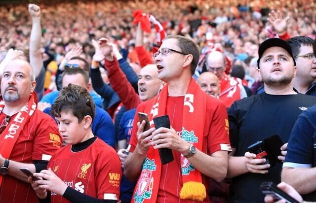 Liverpool fans checked their mobile phones all afternoon at Anfield (Peter Byrne/PA)