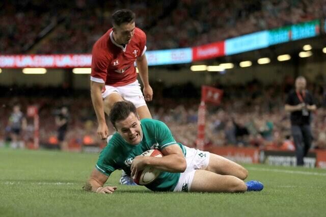Jacob Stockdale in the act of scoring his first of two tries for Ireland against Wales (Adam Davy/PA)