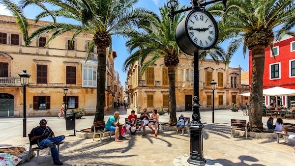 Tourists relaxing on Plaza Alfonzo III, at Ciutadella, on the island of Menorca, Spain