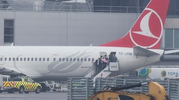 The Turkish Airlines plane carrying Lisa Smith lands at Dublin Airport and Lisa Smith leaves the aircraft with a pink blanket over her head.Photo: Eamonn Farrell/RollingNews.ie.