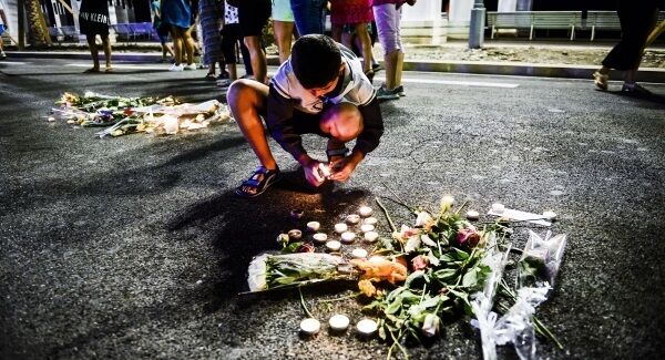 A boy lights a candle placed where bodies fell on the Promenade des Anglais, Nice. Pic: Ben Birchall/PA