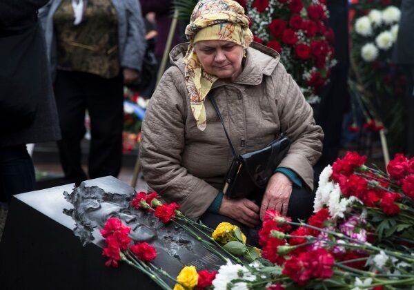 Nataliya Khodemchyuk, 64, widow of Chernobyl liquidator Valery Khodemchyuk, sits at his grave at the Mitino Cemetery in Moscow during a ceremony on the 30th anniversary of the explosion at the Chernobyl nuclear power plant yesterday. Picture: Pavel Golovkin/AP