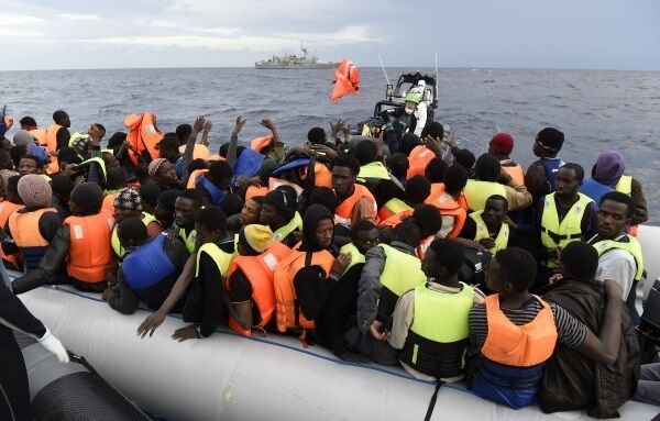 Volunteers help refugees and migrants disembark from a small vessel on the Greek island of Lesbos last year. It is hoped Irish Naval Service missions will be allowed to resume