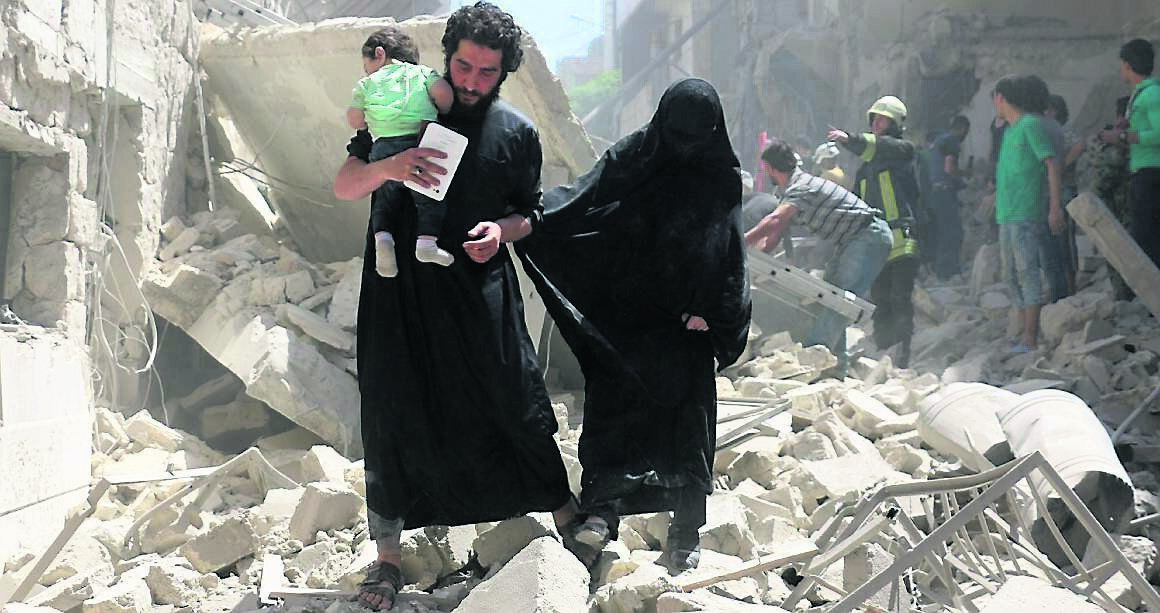 A family walks amid the rubble after a reported air strike in Aleppo last week. The Al Raai family was forced to flee the terror of living in a war-torn country A family walks amid the rubble after a reported air strike in Aleppo last week. The Al Raai family was forced to flee the terror of living in a war-torn country