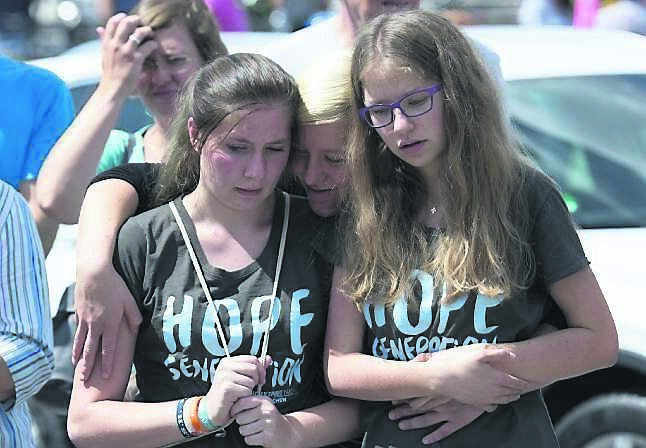 Two young women mourn beside the Olympia shopping centre in Munich yesterday.