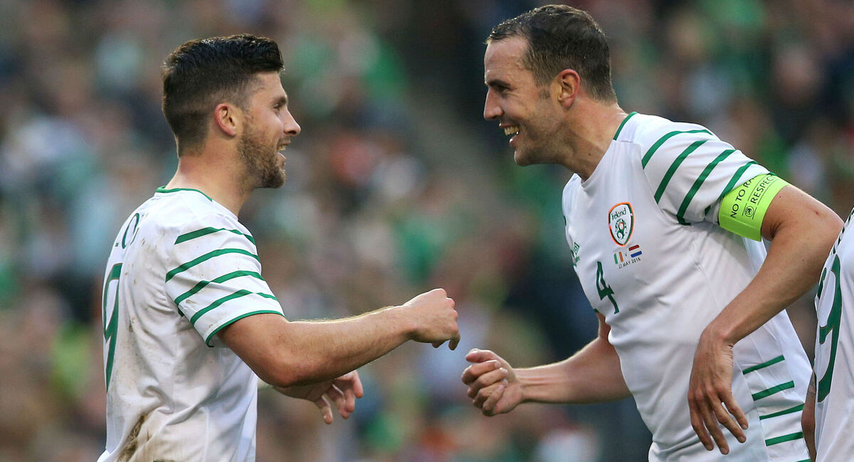 Shane Long celebrates scoring the first goal of the game with John O'Shea at the Aviva Stadium. Photo: Brian Lawless/PA