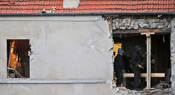 People work inside the building of Wednesday’s raid in Saint-Denis.