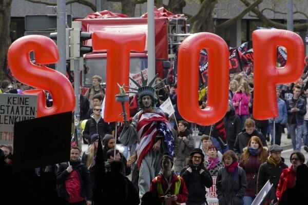 A man on stilts and dressed like the Statue of Liberty walks in front of balloons forming the slogan Stop TTIP during a protest of thousands of demonstrators against the planned Transatlantic Trade and Investment Partnership, TTIP, and the Comprehensive Economic and Trade Agreement, CETA, ahead of the visit of United States President Barack Obama in Hannover, Germany. A man on stilts and dressed like the Statue of Liberty walks in front of balloons forming the slogan Stop TTIP during a protest of thousands of demonstrators against the planned Transatlantic Trade and Investment Partnership, TTIP, and the Comprehensive Economic and Trade Agreement, CETA, ahead of the visit of United States President Barack Obama in Hannover, Germany.