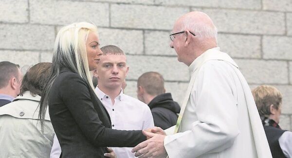 Amanda Gilbert, who lost her pregnant sister Tara and nieces Jodie and Kelsey in the blaze, is comforted by Monsignor Dermot Lane. Pic: Gareth Chaney Collins