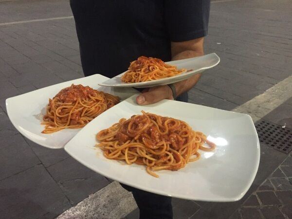 Waiter Andrea Orsini serves pasta all’amatriciana. Restaurants are being urged to put the dish on their menus with a €2 donation going to the Italian Red Cross for each dish sold. Picture: Gregorio Borgia/AP