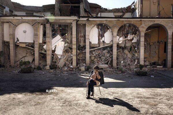 A woman sits in the courtyard of the Don Minozzi convent in Amatrice, central Italy. Picture: Roberto Salomone/ANSA via AP