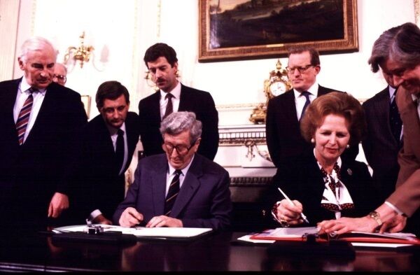 Peter Barry, Dick Spring, and Tom King witness Garret Fitzgerald and Margaret Thatcher signing the Anglo-Irish Agreement in 1985
