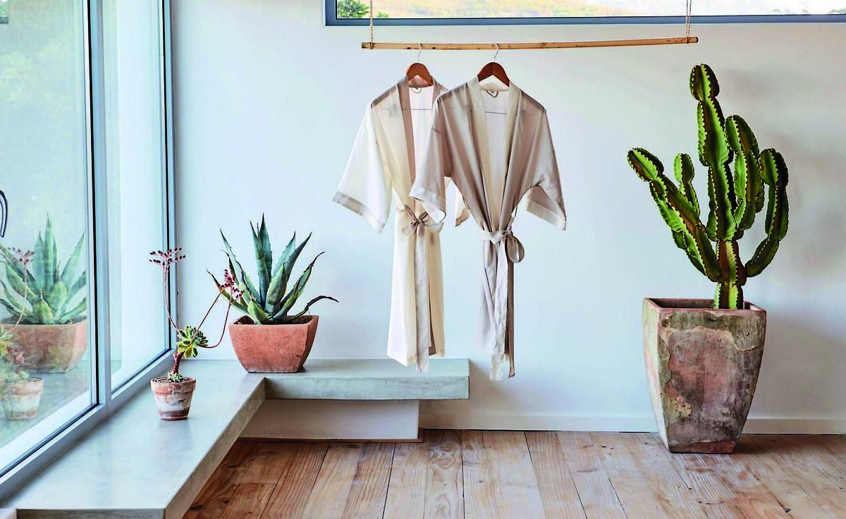 A formed concrete bench polished to reveal its subtle beauty forms an unfussey tranquil seating corner. Hone edges for comfort. Cacti are one of a number of succulents that can survive the challenge of a reasonably ventilated bathroom. Flooring is simple deal planks with gentle white-wash finish. Accessories by Urbanara. A formed concrete bench polished to reveal its subtle beauty forms an unfussey tranquil seating corner. Hone edges for comfort. Cacti are one of a number of succulents that can survive the challenge of a reasonably ventilated bathroom. Flooring is simple deal planks with gentle white-wash finish. Accessories by Urbanara.