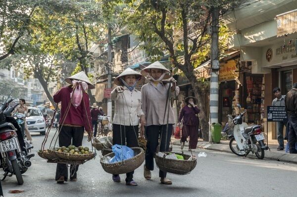 Women wearing traditional non la hats going about their daily business in the Vietnamese capital, Hanoi.