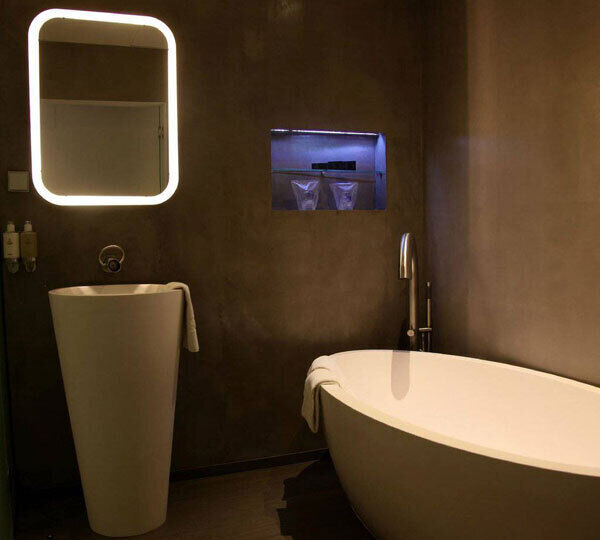 The bathroom has sleek lines with clever lighting.