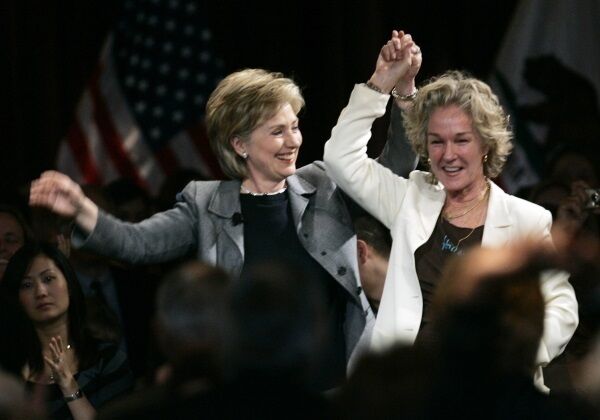 Presidential candidate Hillary Clinton, holds hands with Esprit clothing co-founder, Susie Tompkins Buell, right, at a fundraising luncheon in San Francisco.