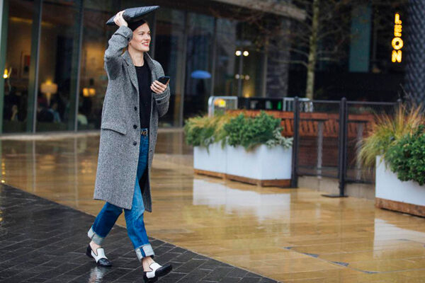 Jo Ellison, FT fashion editor, wears a patterned gray coat, jeans, and black and white loafers and shields herself from the rain with a black leather portfolio during London Fashion Week Autumn/Winter 2016/17 at the Anya Hindmarch show at Kings Cross on February 20, 2016 in London. Jo Ellison, FT fashion editor, wears a patterned gray coat, jeans, and black and white loafers and shields herself from the rain with a black leather portfolio during London Fashion Week Autumn/Winter 2016/17 at the Anya Hindmarch show at Kings Cross on February 20, 2016 in London.