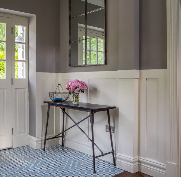 A hallway at Foxrock, Dublin where cafe creme colours are brightened by blue encaustic tiles. Again, a mirror is used to refect light back into the hallway.