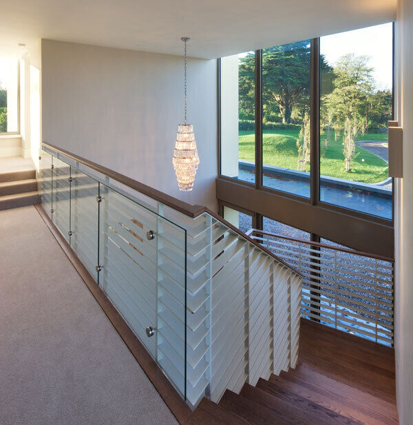 A cantilevered stairs leads to a light-filled mezzanine landing while outside 65 concrete fins support canopies, providing views of the two-and-a-half acres of landscaped gardens.