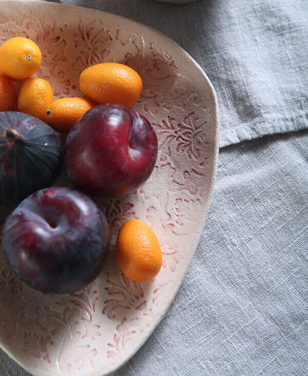 The creation of these impressed plates starts with a flat piece of clay which has been textured front and back with wallpaper patterns. A bright wash of colour is then applied before glazing. The triangular shape has softly rounded edges so that they will easily sit in your hand. The latest editions are available in blue deco, ruby damask, green seeds and the new midnight flora surface patterns and colours. The plates retail between €26- €46.
