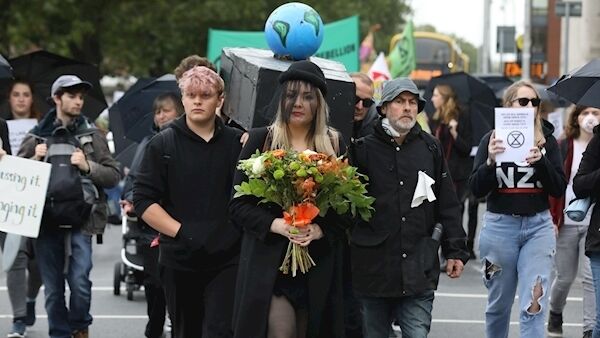 Extinction Rebellion protesters carry a coffin with a globe on top outside the Four Courts in Dublin this morning.Pic: Collins