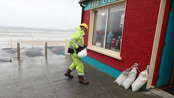 Members of Clare County council place sandbags at shops on the sea front in Lahinch, County Clare. (Brian Lawless/PA Wire)