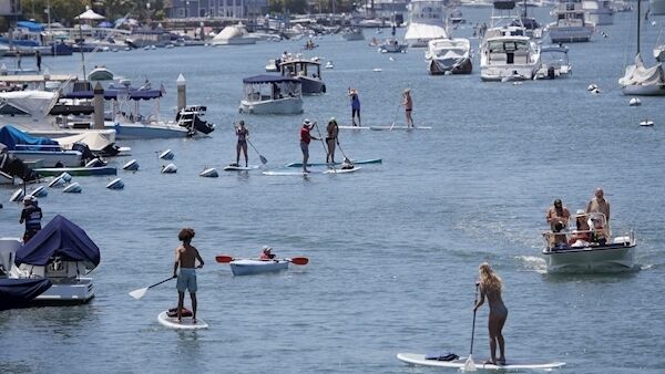 Boaters and paddle boarders use a harbor in Newport Beach, California, yesterday. Pic: AP