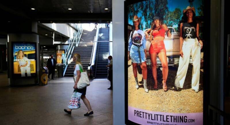 A shopper walks pass advertising billboards for Boohoo and for 'Pretty Little Things', a Boohoo brand, at Canary Wharf DLR station in central London, Britain, September 17, 2018. REUTERS/James Akena/File Photo A shopper walks pass advertising billboards for Boohoo and for 'Pretty Little Things', a Boohoo brand, at Canary Wharf DLR station in central London, Britain, September 17, 2018. REUTERS/James Akena/File Photo
