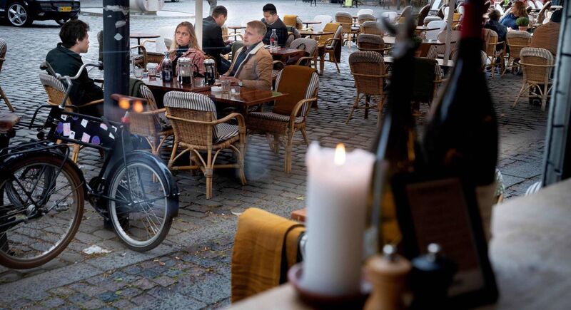 People sit at the terrasse of the Huks Fluks restaurant after it reopened at Graabroedre Square in Copenhagen on May 18. Pic: Liselotte Sabroe AFP