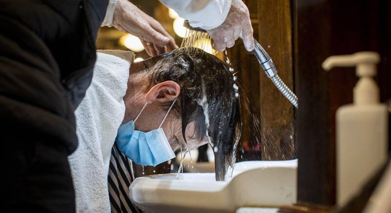A customer has his hair washed at Cambridge Barbershop on Belfast's Lisburn Road yesterday as hairdressers and beauty salons reopen in Northern Ireland. Photo: Liam McBurney/PA Wire A customer has his hair washed at Cambridge Barbershop on Belfast's Lisburn Road yesterday as hairdressers and beauty salons reopen in Northern Ireland. Photo: Liam McBurney/PA Wire