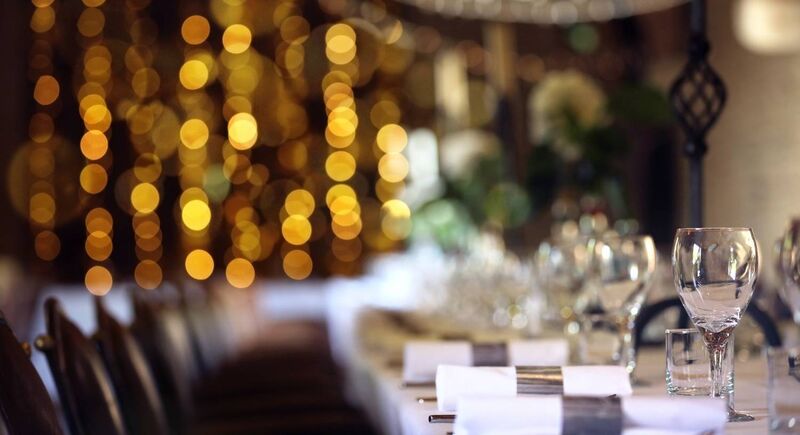 Formal wedding place setting on long table background focus on wine glass