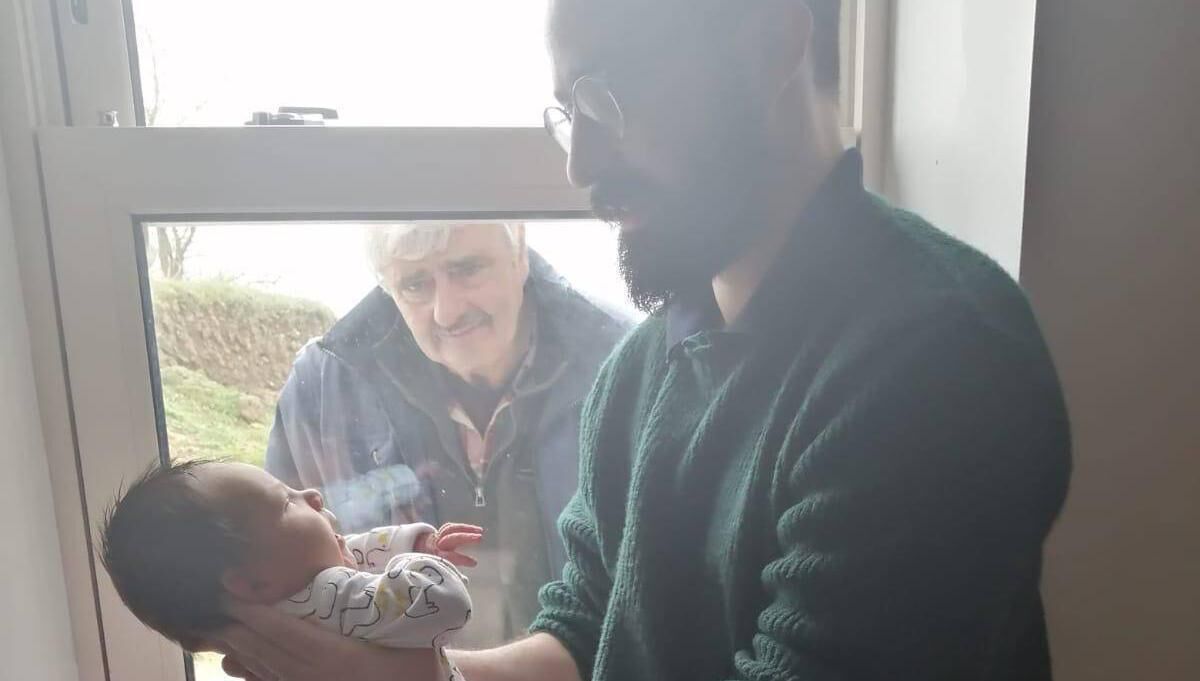 An earlier picture of Michael meeting his grandson through a window during Covid-19 cocooning. Pictured is Michael, Micheál and grandson Faolán.