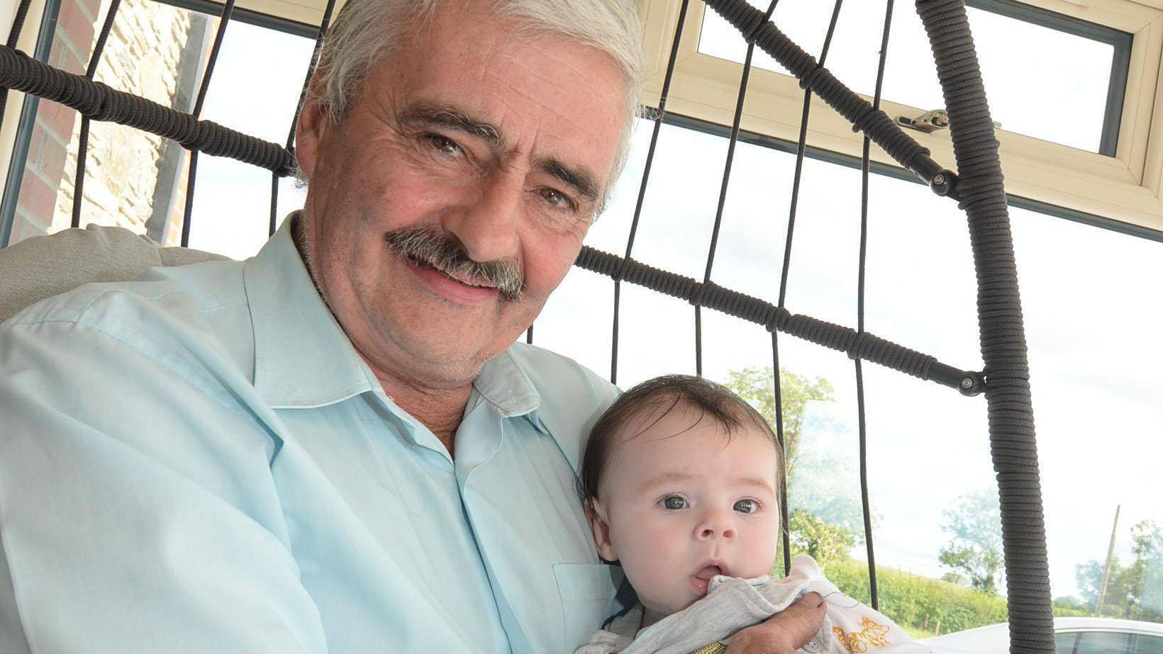 Doting grandfather whose image went viral finally gets to hold his baby grandson - 15 weeks later