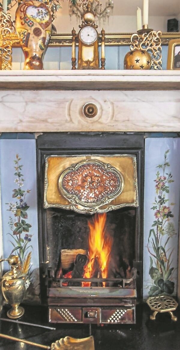 Elaborate Victorian style fireplace with patterned tiled inserts and intricate cast iron surrounds Elaborate Victorian style fireplace with patterned tiled inserts and intricate cast iron surrounds