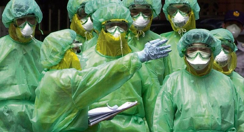 Taipei medical workers in full protective body suits at an infected housing complex in Taiwan in 2003 during the Sars epidemic.