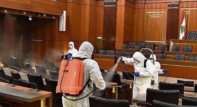 Workers spray disinfectant as a precaution in the main hall of the Lebanese parliament, in Beirut, yesterday. 	 Picture: AP