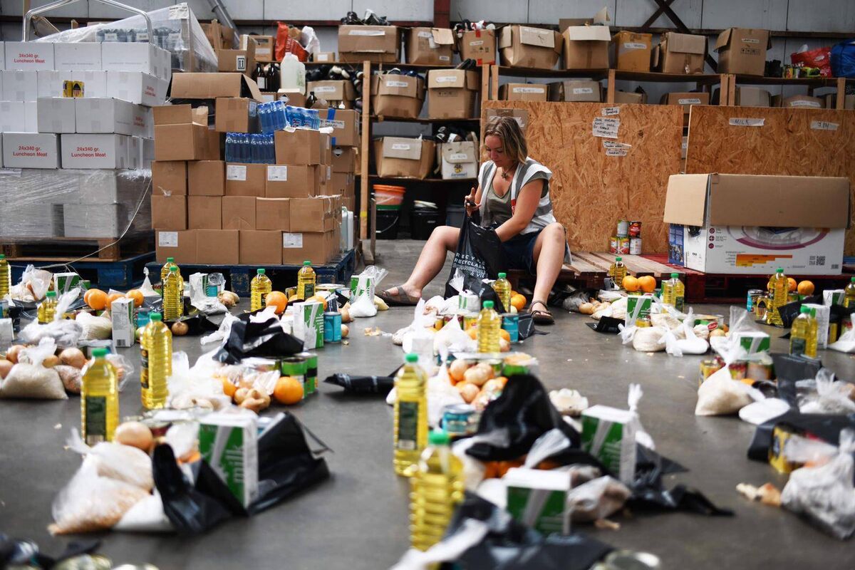 Holly prepares food packs, filled with tinned and fresh food, in the Care4Calais warehouse. Holly prepares food packs, filled with tinned and fresh food, in the Care4Calais warehouse.