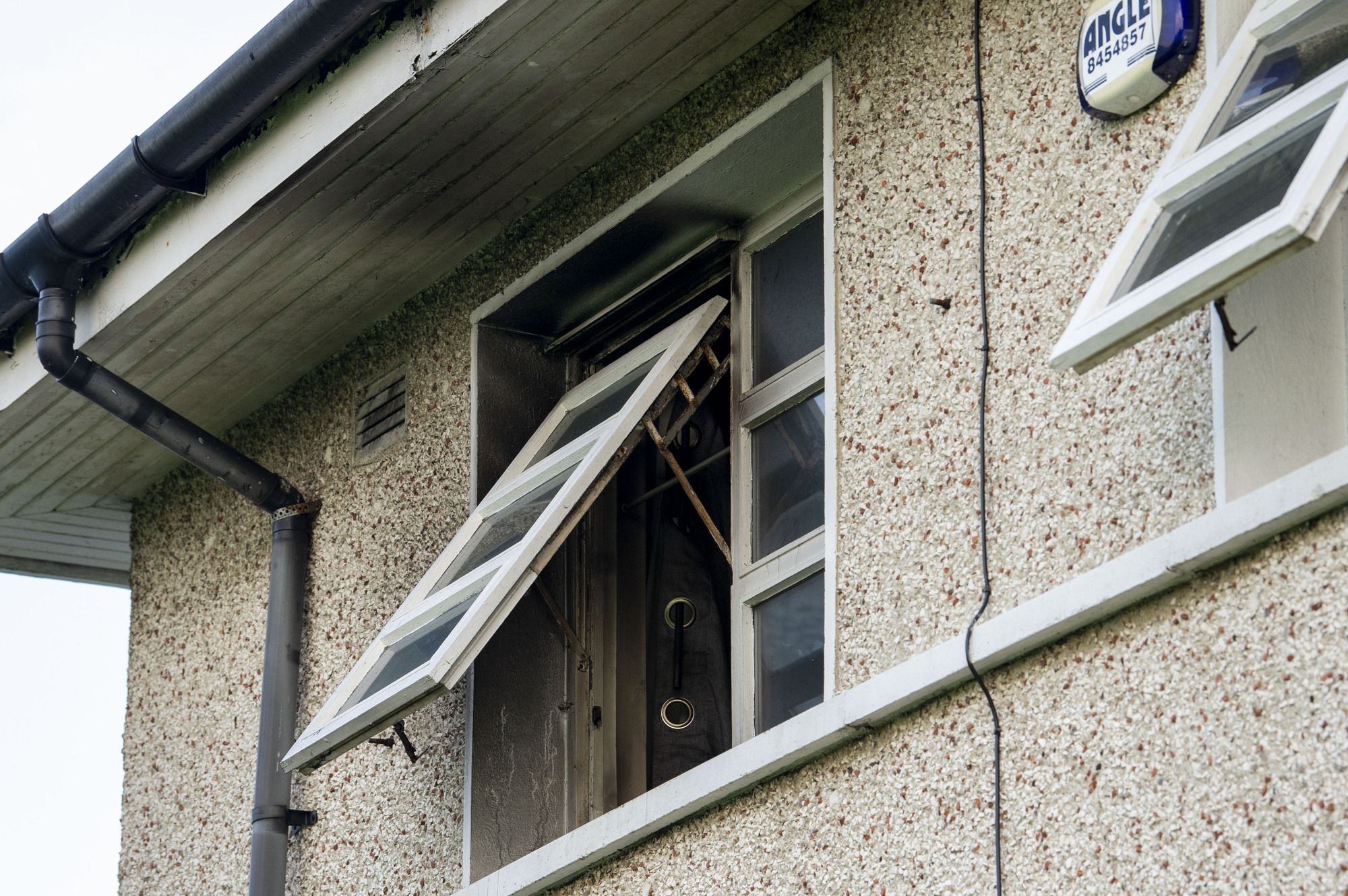 Pictured is the window above the front door which is situated at the side of the house. The black smoke is visible on the paint around the window.