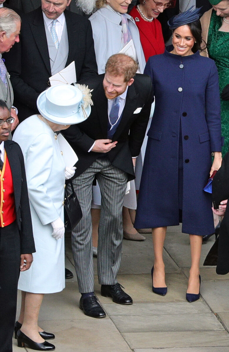 Queen Elizabeth II speaks with the Duke and Duchess of Sussex outside St George's Chapel in Windsor Castle, following the wedding of Princess Eugenie to Jack Brooksbank. Picture: Aaron Chown/PA Wire