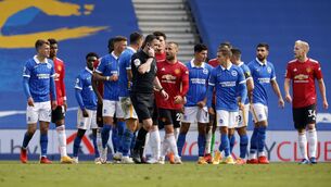 <p>Chris Kavanagh is surrounded by players in the final moments of the game as he checks a VAR penalty decision which resulted in Manchester United's Miguel Bruno Fernandes scoring the winning goal during the Premier League match at the AMEX Stadium, </p>