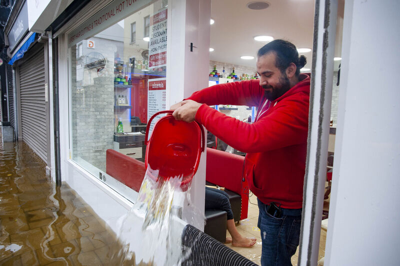  Staff clean up in Zizenia Barbers during heavy flooding on Oliver Plunkett street, Cork city. Picture:  Daragh McSweeney/Provision