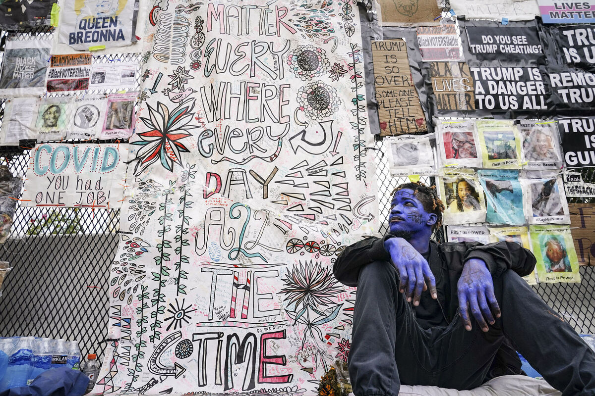 A demonstrator going by the name Azul Azul sits on a sidewalk outside the White House in Washington yesterday. Picture: AP