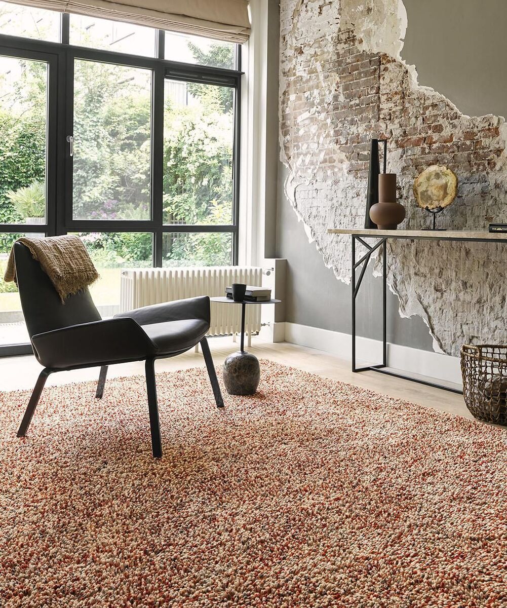  Broken plasterwork is turned into a wall feature, highlighted by soft green paintwork, where a deep pile floor rug is added for comfort and warmth (Brink &amp; Campman Pop Art rug from €699 at Rugs.ie).