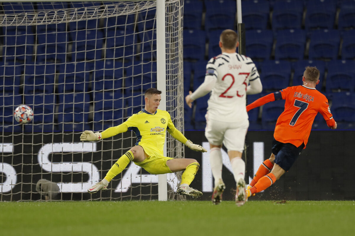 Manchester United's goalkeeper Dean Henderson, left, fails to save the ball as Basaksehir's Edin Visca, right, scores his side's second goal. 