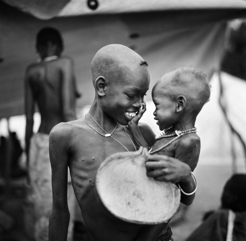 A rare moment of joy between siblings at Ajiep, in Bahr El Ghazal Province, south Sudan during the devastating famine of 1998. Photo: Tom Stoddart A rare moment of joy between siblings at Ajiep, in Bahr El Ghazal Province, south Sudan during the devastating famine of 1998. Photo: Tom Stoddart